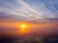 Glühender Sonnenaufgang am Horizont über dem Chiemsee